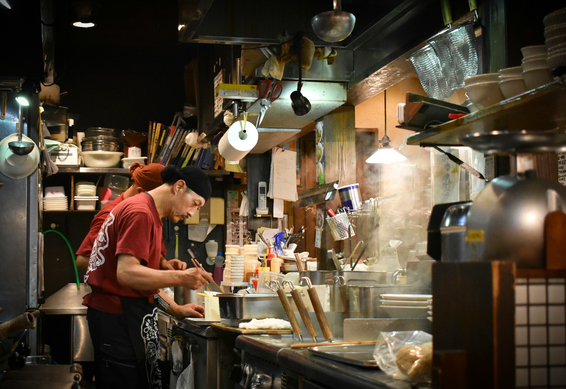 A man cooking at the hob in his kitchen.