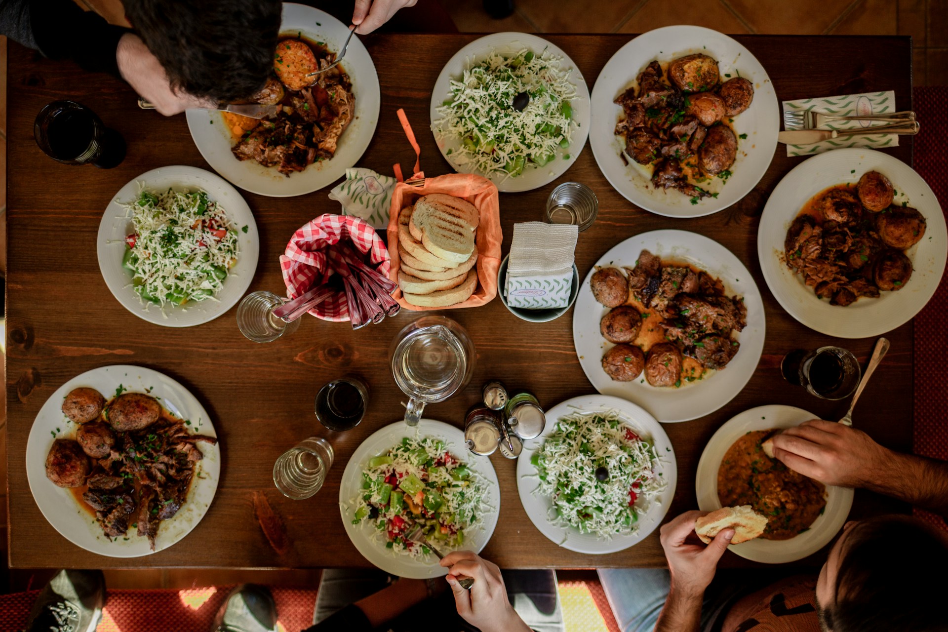 White plates of different foods laid out on a table.
